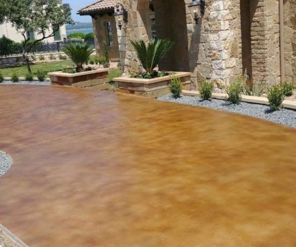 A stained concrete patio has been transformed into a beautiful outdoor living space, perfect for entertaining and relaxing.